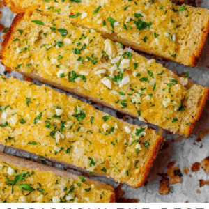 Sliced garlic bread topped with chopped parsley and minced garlic, displayed on parchment paper. Text at the bottom reads: Seriously delicious Garlic Bread of your life. The Food Charlatan.