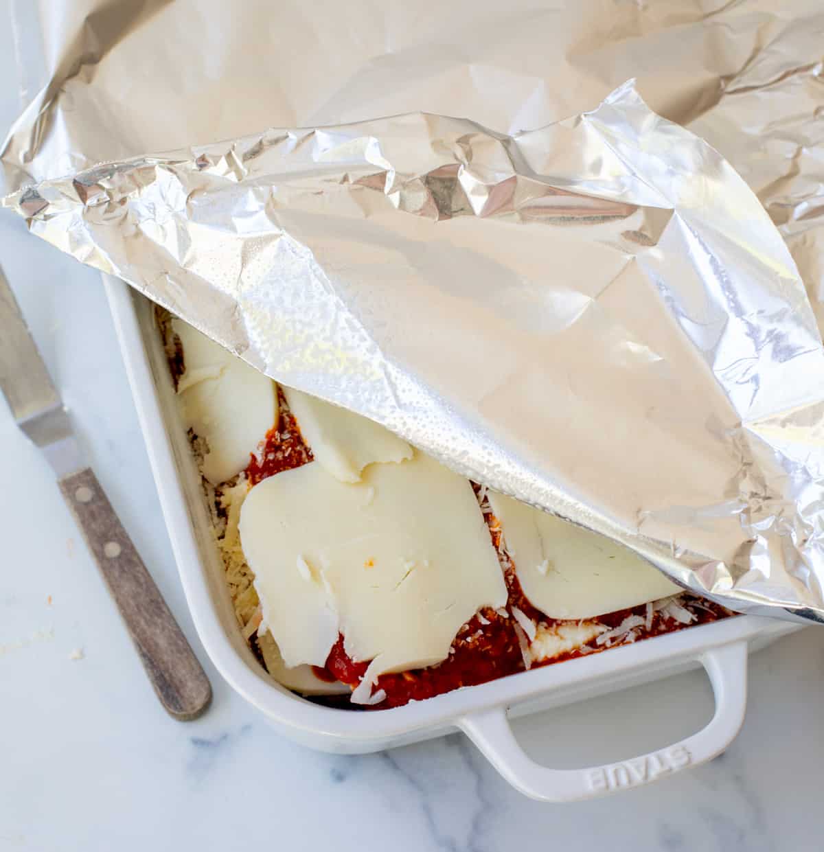 a pan of the best lasagna covered with greased aluminum foil.