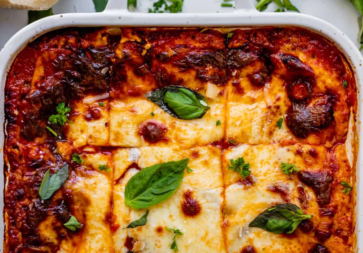 overhead shot of a pan of lasagna topped with basil.