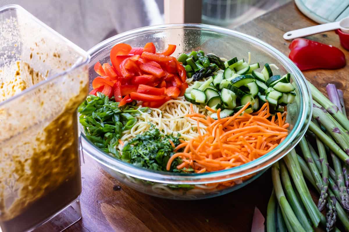 peppers, cucumber, carrots, cilantro, green onion, and asparagus in with cooked noodles.