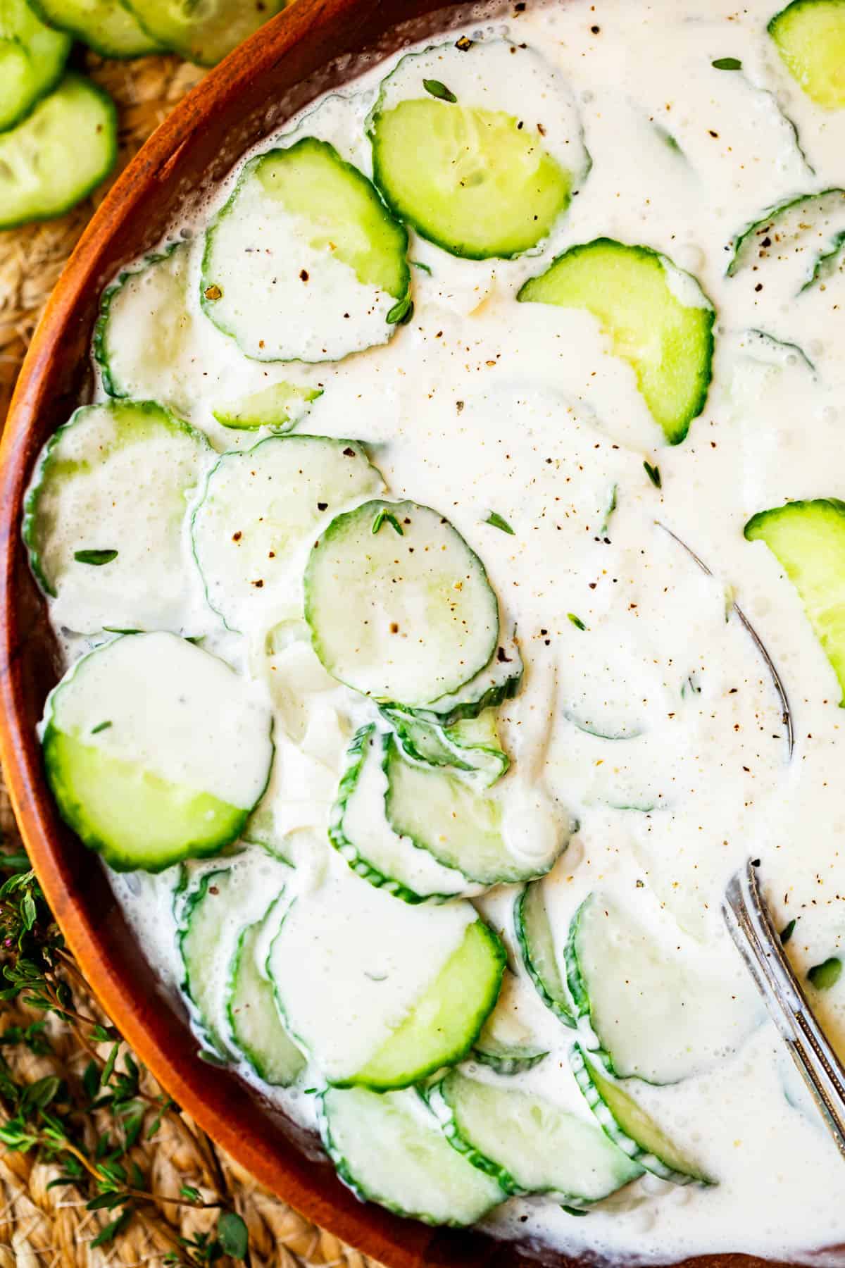 creamy cucumber salad with mayo in a wooden bowl shot from overhead.