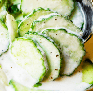 close up shot of Creamy cucumber salad held up by a spoon.
