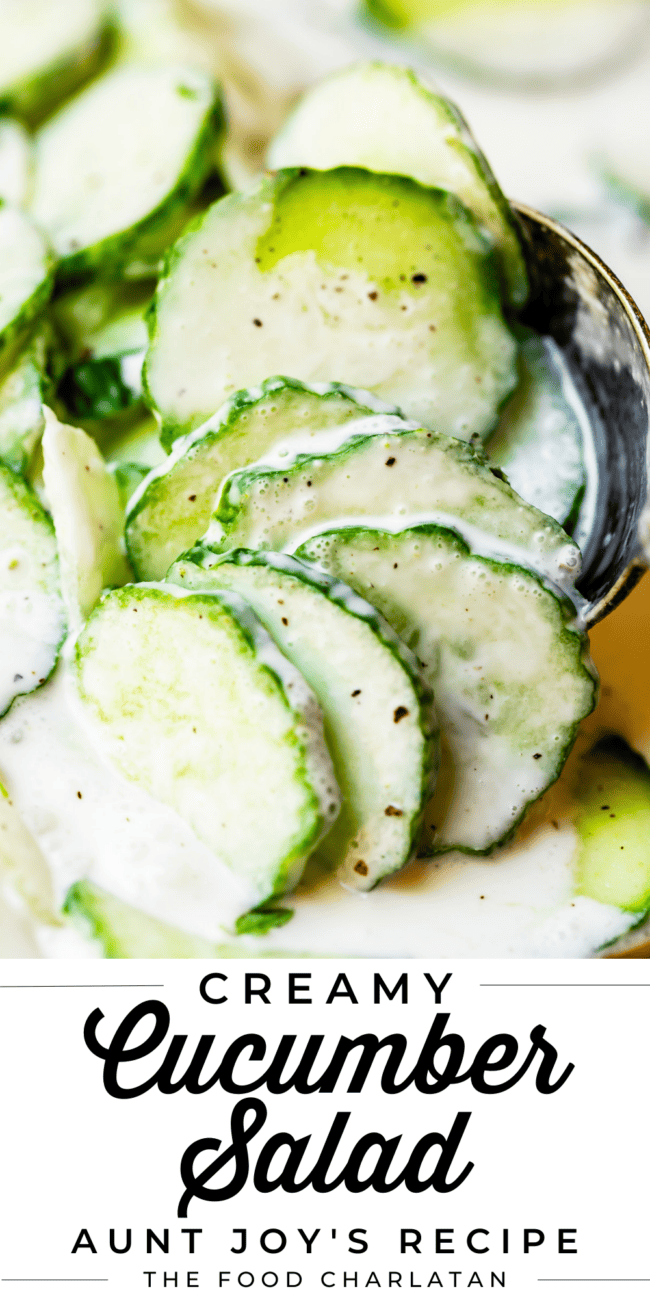 close up shot of Creamy cucumber salad held up by a spoon.
