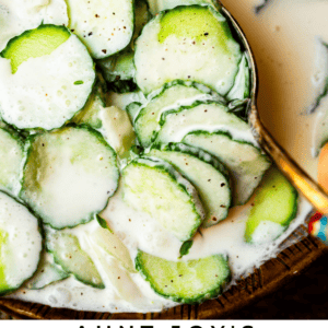 creamy cucumber salad recipe in a bowl with a spoon.