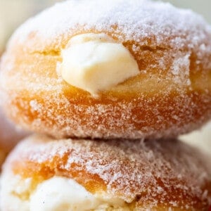 two stacked homemade donuts puffy with Bavarian cream filling and sugar rolled.