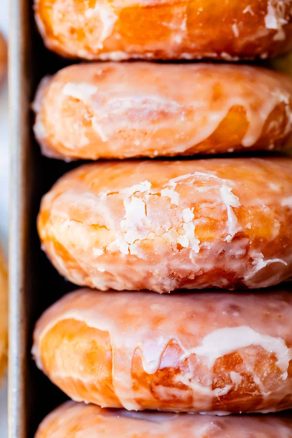 side view of a stack of the best donuts showing the cracks of the glaze.