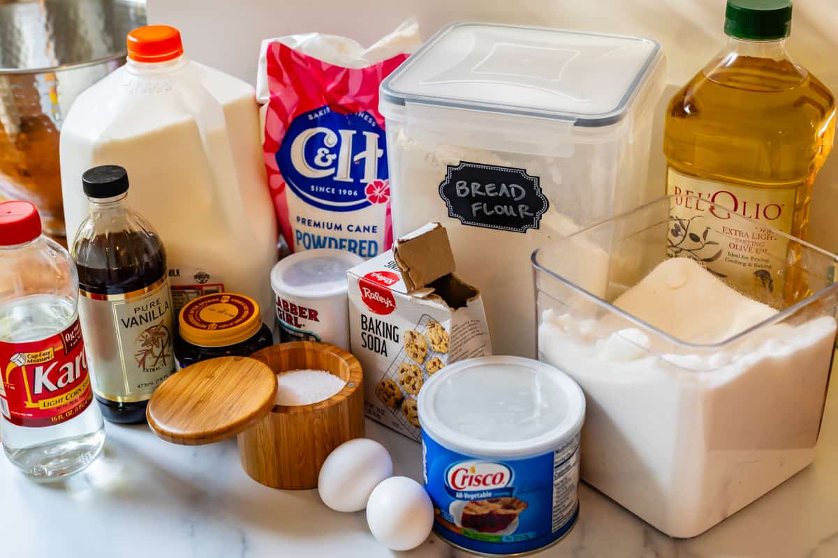 ingredients for making homemade donuts- flour, sugar, yeast, milk, eggs, and more.