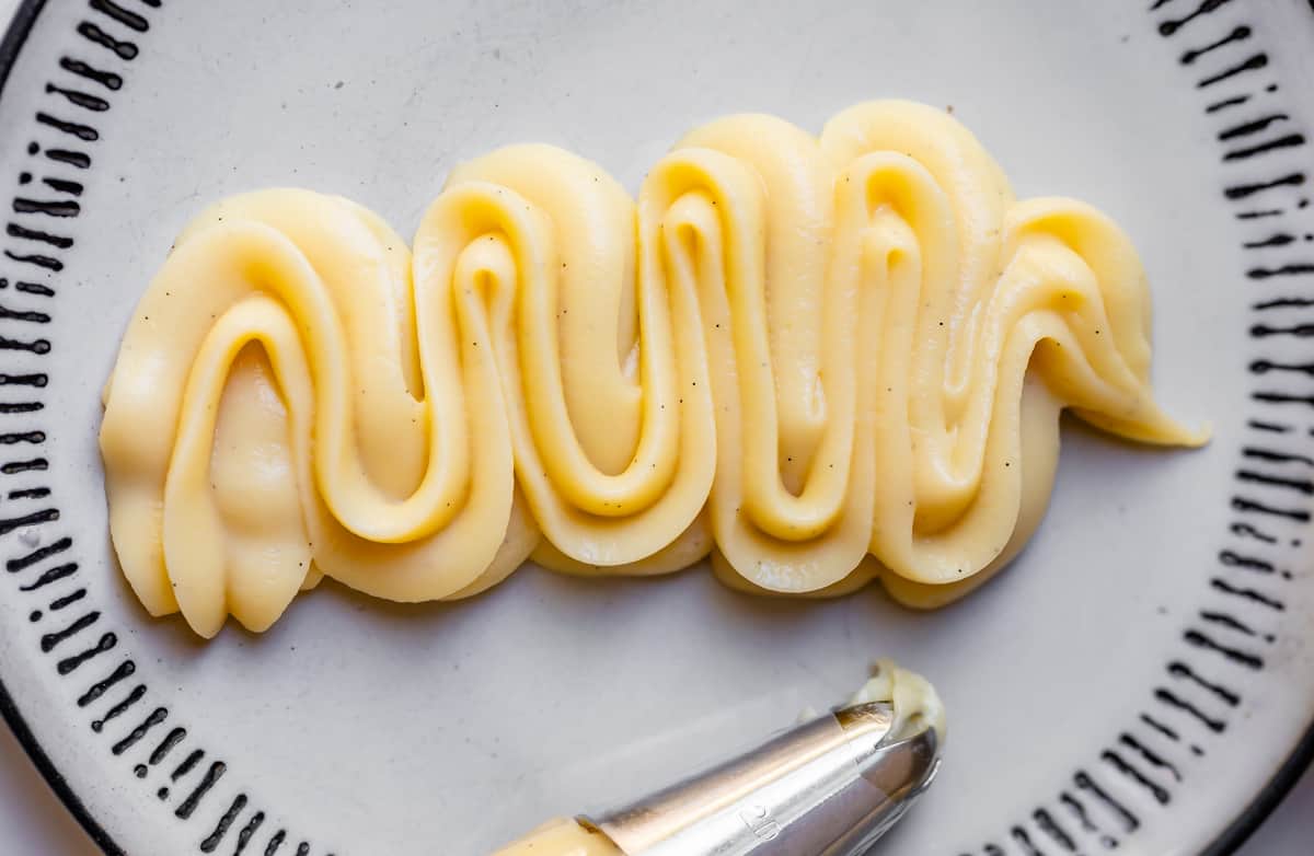 close up of piped pastry cream on a plate showing it does not fall or lose shape.