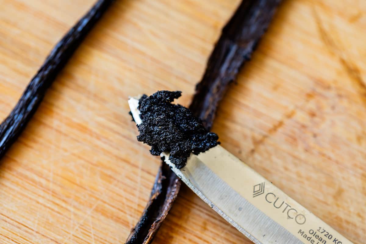 close up of a knife that has scraped out the inside of a vanilla pod to add to the pastry cream.