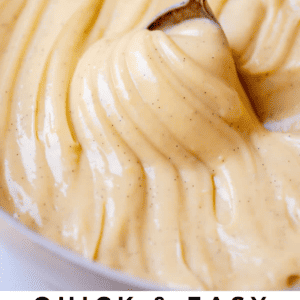 swirly pastry cream in a bowl being lifted with a spoon.