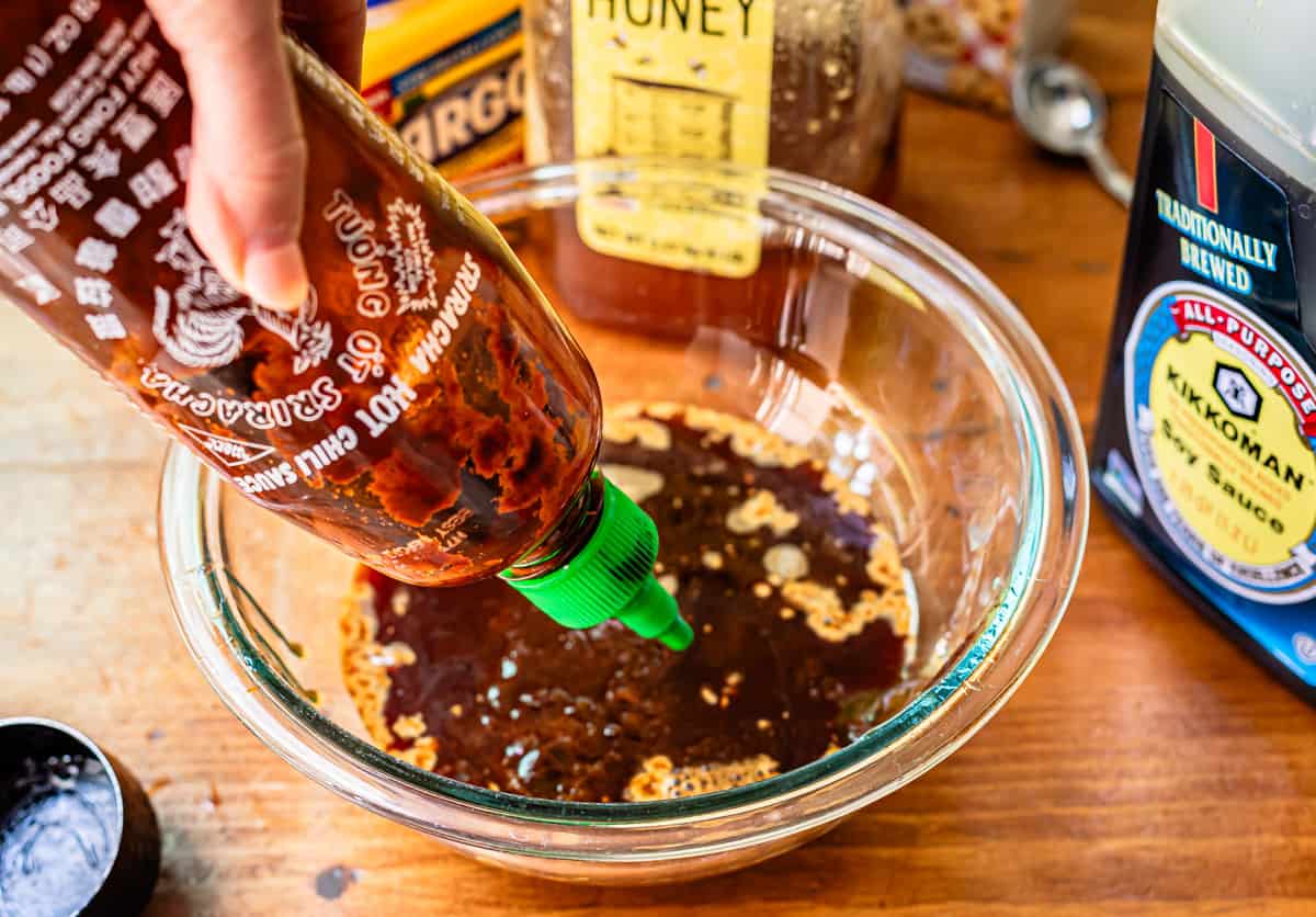 a bottle adding one or two squirts of sriracha to the mixing bowl with the honey.
