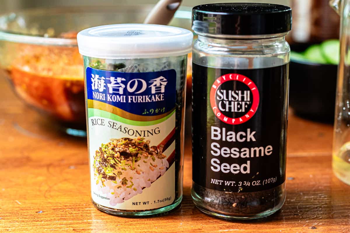 containers showing what a bottle of rice seasoning and a bottom of black sesame seeds look like.