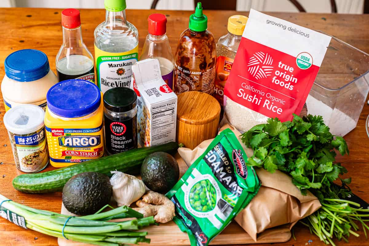 all ingredients for honey sriracha salmon bowls displayed - sushi rice, salmon, edamame, etc.