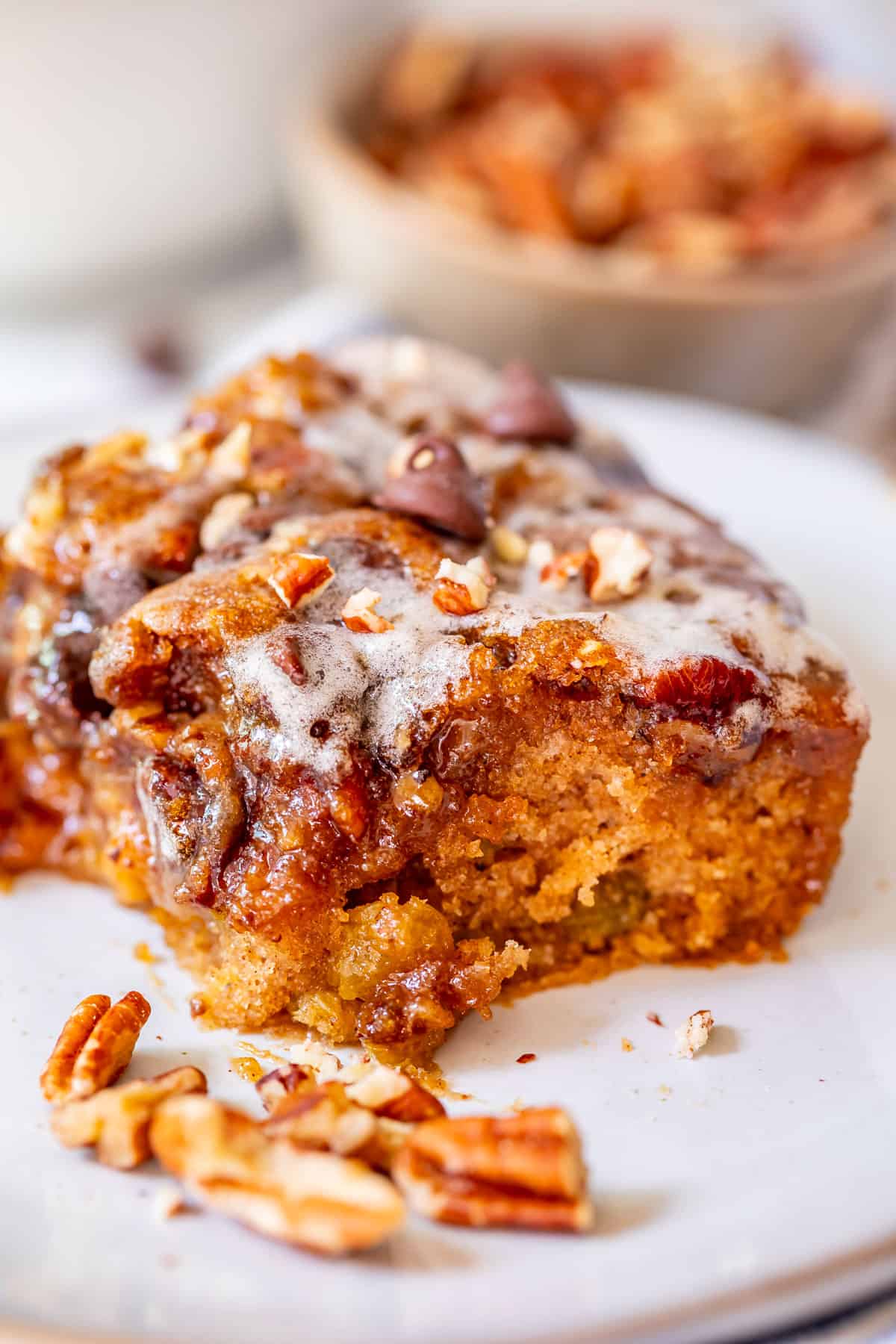 cut piece of homemade picnic cake on a white plate with a bite taken out of it.