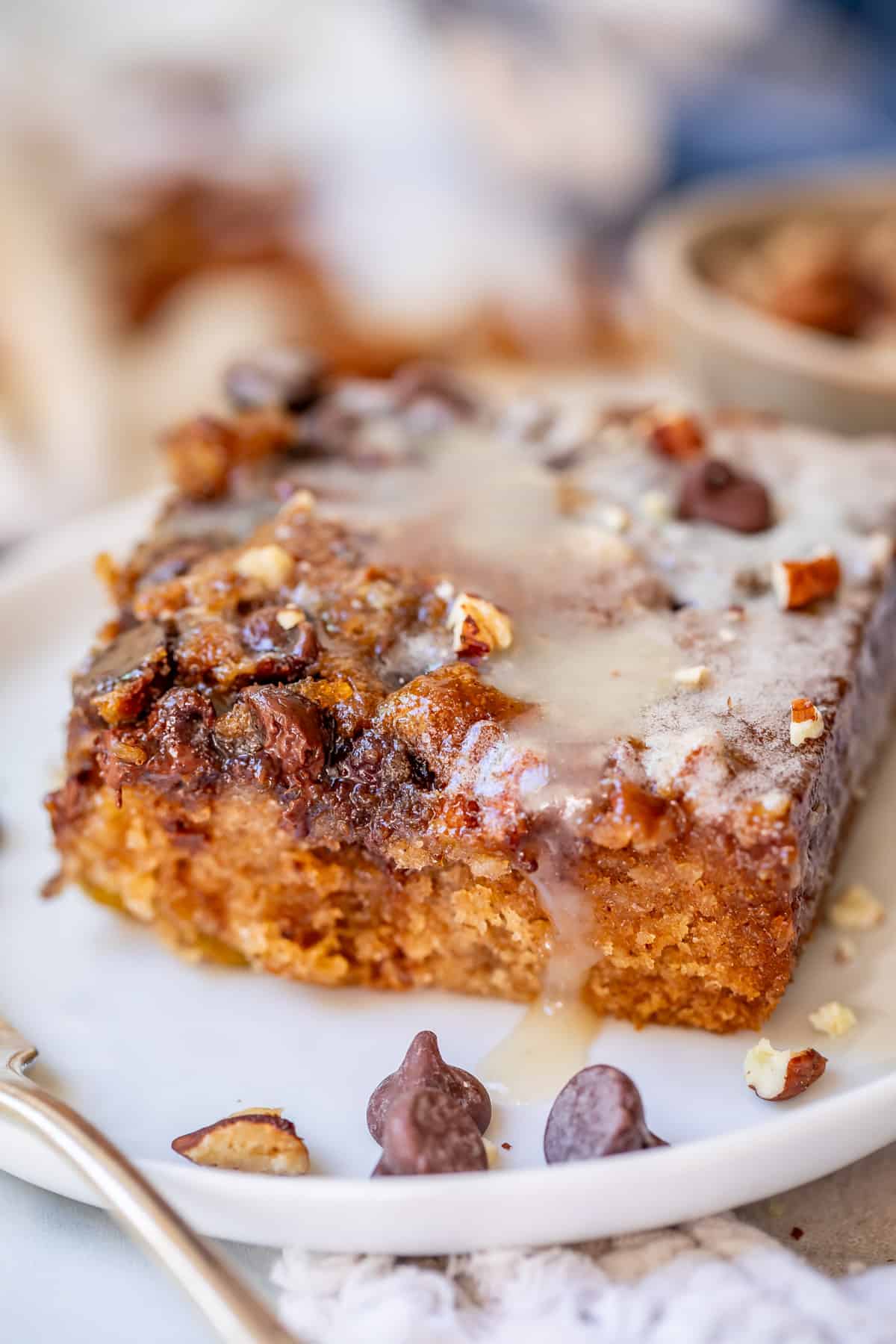 picnic cake with buttermilk glaze and brown sugar pecan chocolate topping on a ceramic plate.