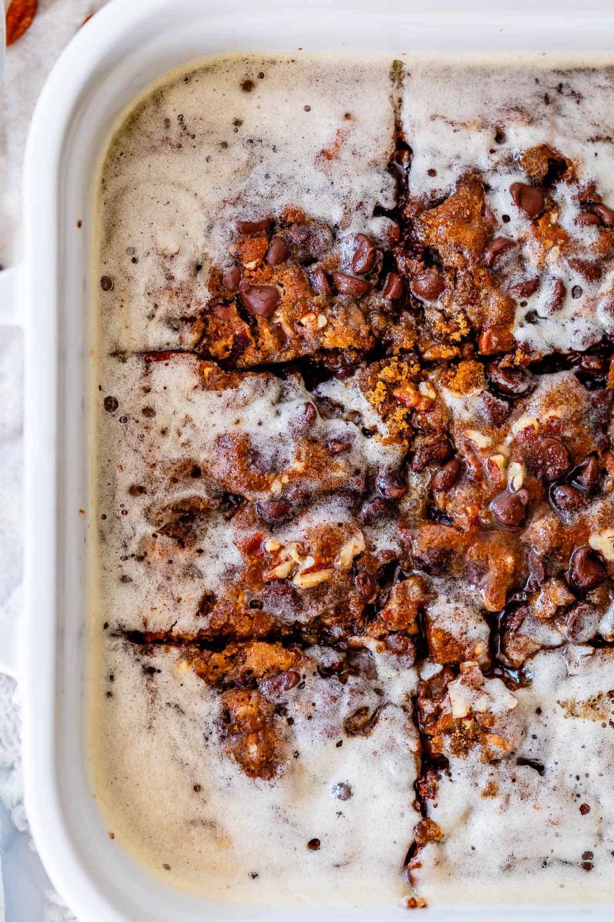 overhead shot of baked cake with buttermilk syrup glaze in a white dish.