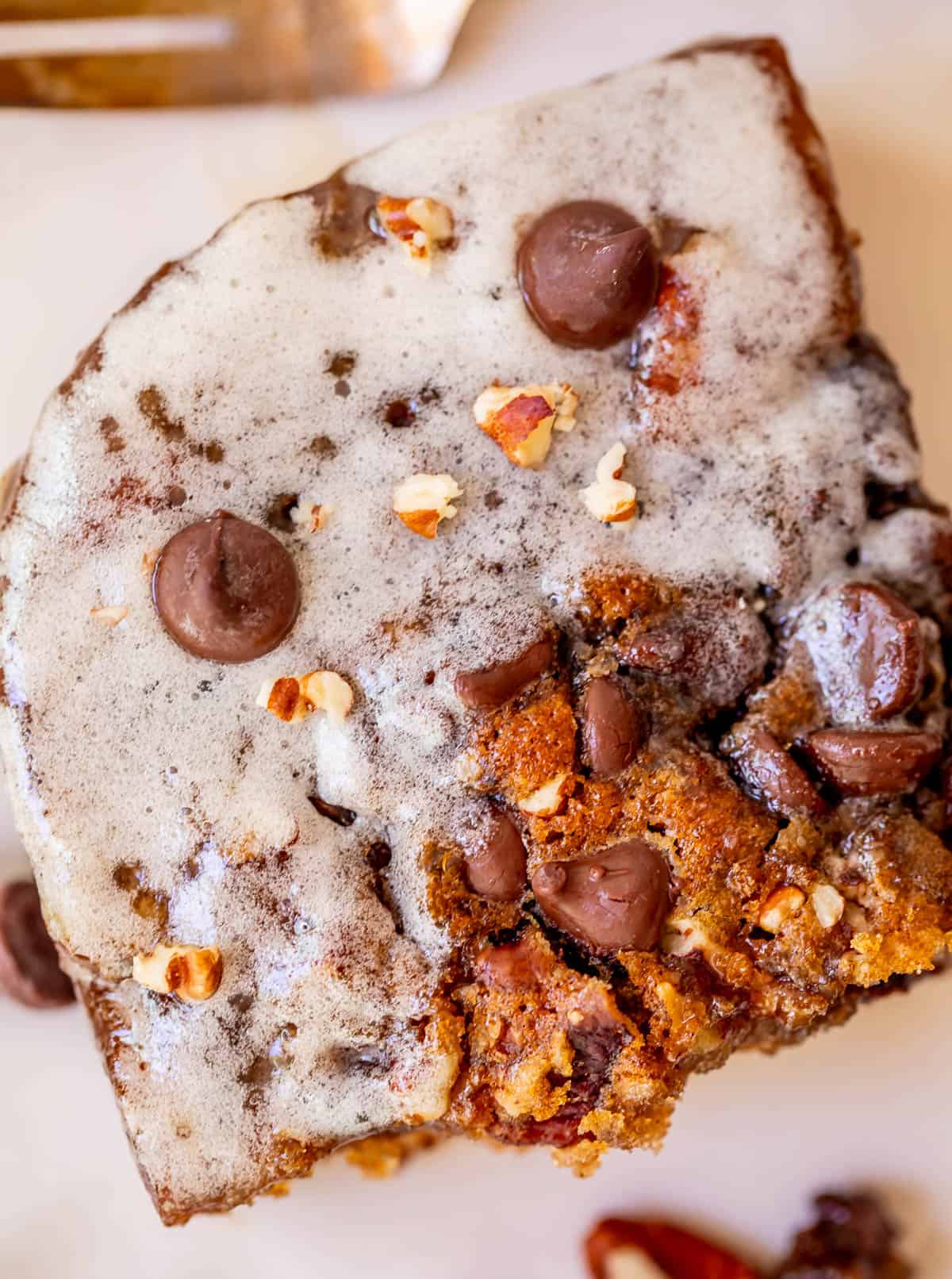 close up of a cut piece of picnic cake showing the glaze, chocolate chips, and more.