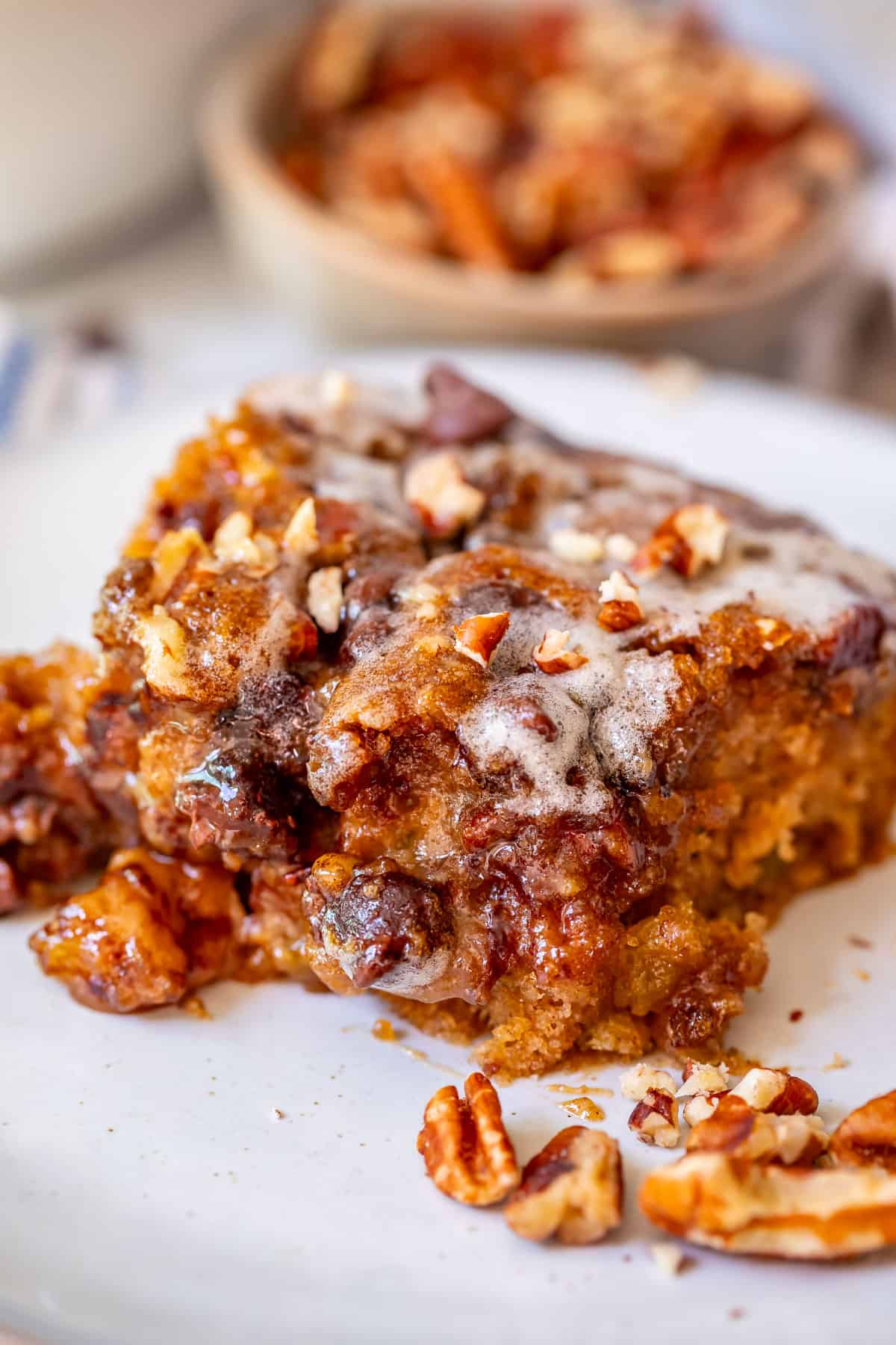 cut piece of cake showing off the amazing topping of pecans, chocolate, and glaze.