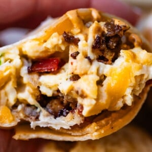 Horizontal shot of breakfast burrito with cheese and hashbrowns.