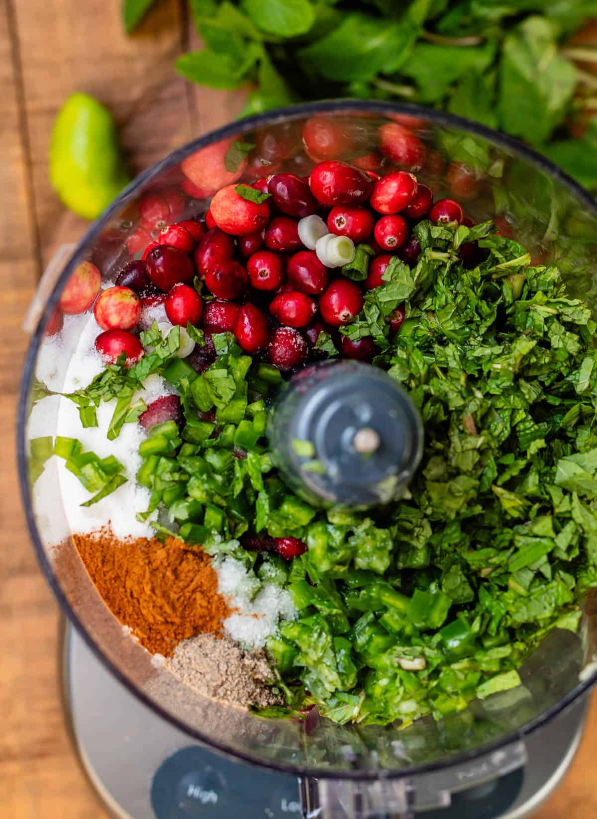 cranberries, sugar, mint, and diced jalapeño ready to be chopped up in a food processor.