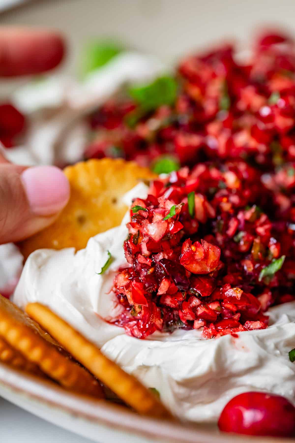 cranberry jalapeño dip on ritz cracker with whipped cream cheese.