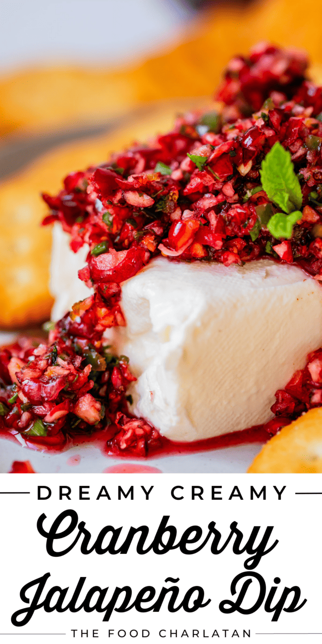 block of cream cheese on a plate with cranberry salsa on top, garnished with mint.