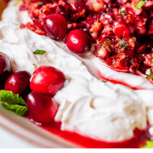 whipped cream cheese topped with cranberry jalapeno dip and fresh cranberries.