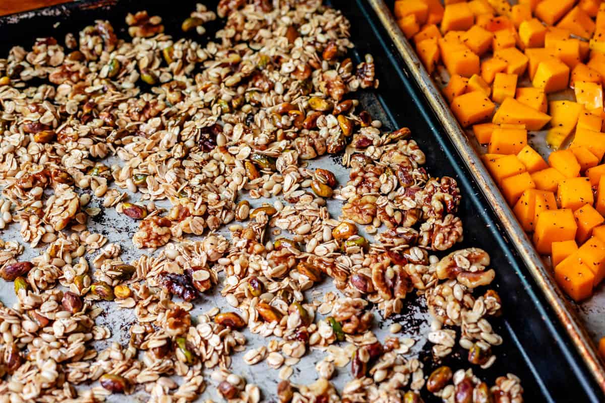granola ingredients spread out on a baking sheet ready to be baked.