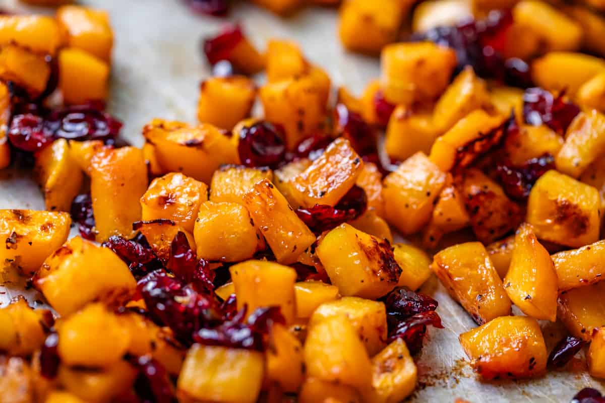 close up showing all the crispy bits of roasted squash with some dried cranberries mixed in.