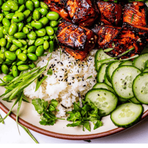bowl of edamame, crispy salmon, cucumbers, avocado, rice.