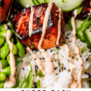 close up shot of blackened salmon drizzled with sriracha mayo, cucumbers in the background.