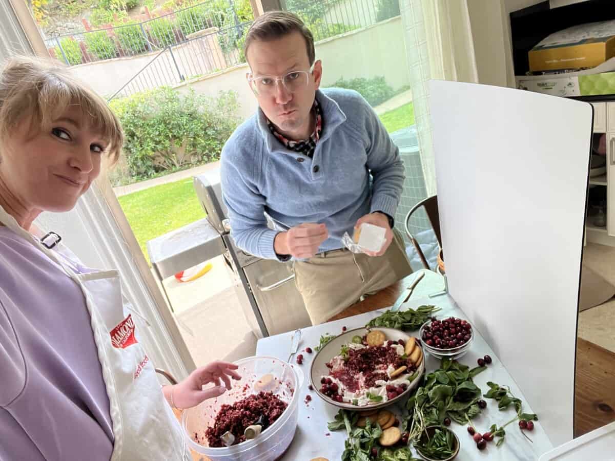 woman and man eating dip by a window.