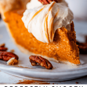slice of sweet potato pie on a plate with pecans, topped with caramel whipped cream.
