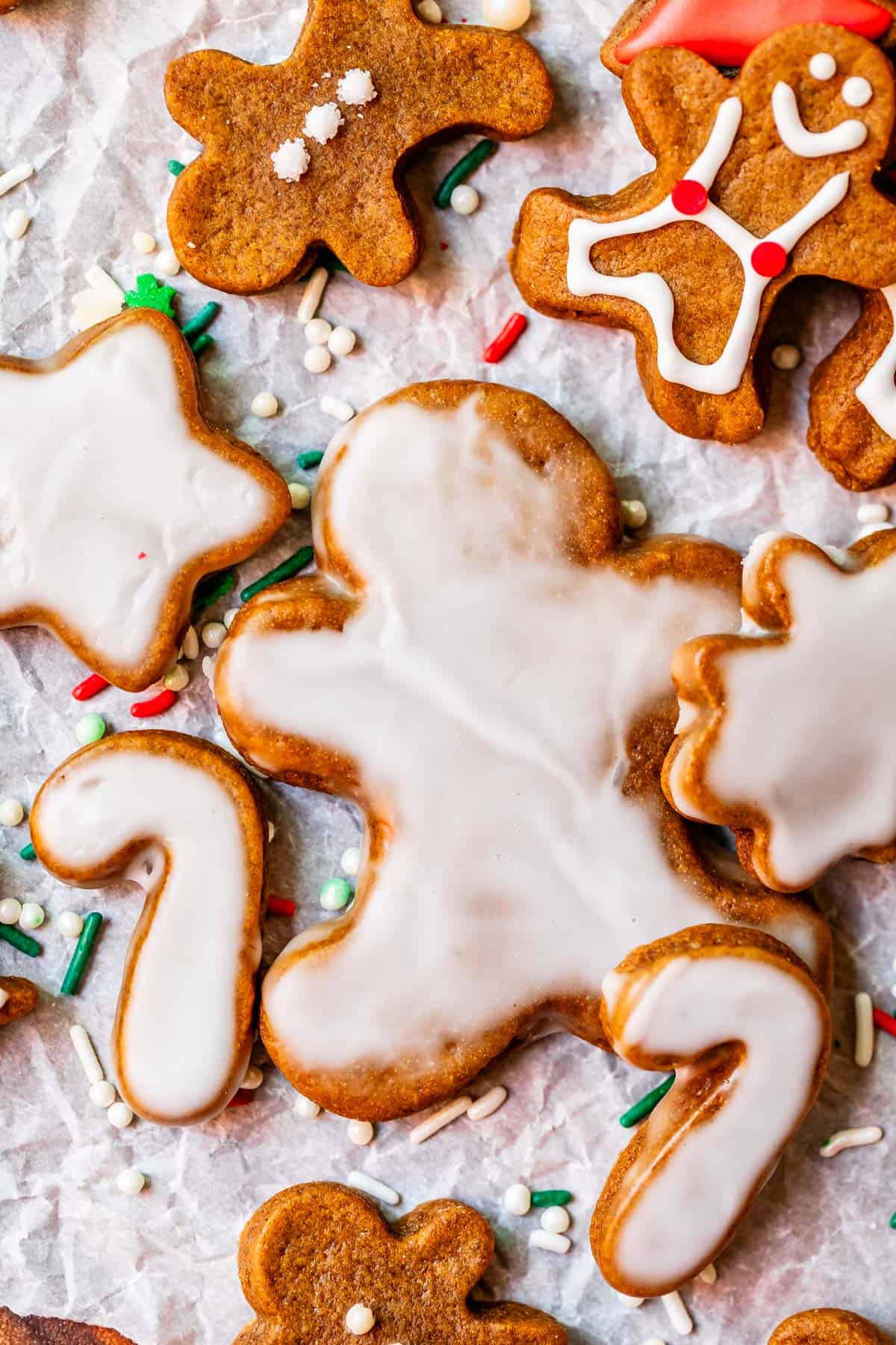 glazed gingerbread man cookies on paper with sprinkles.