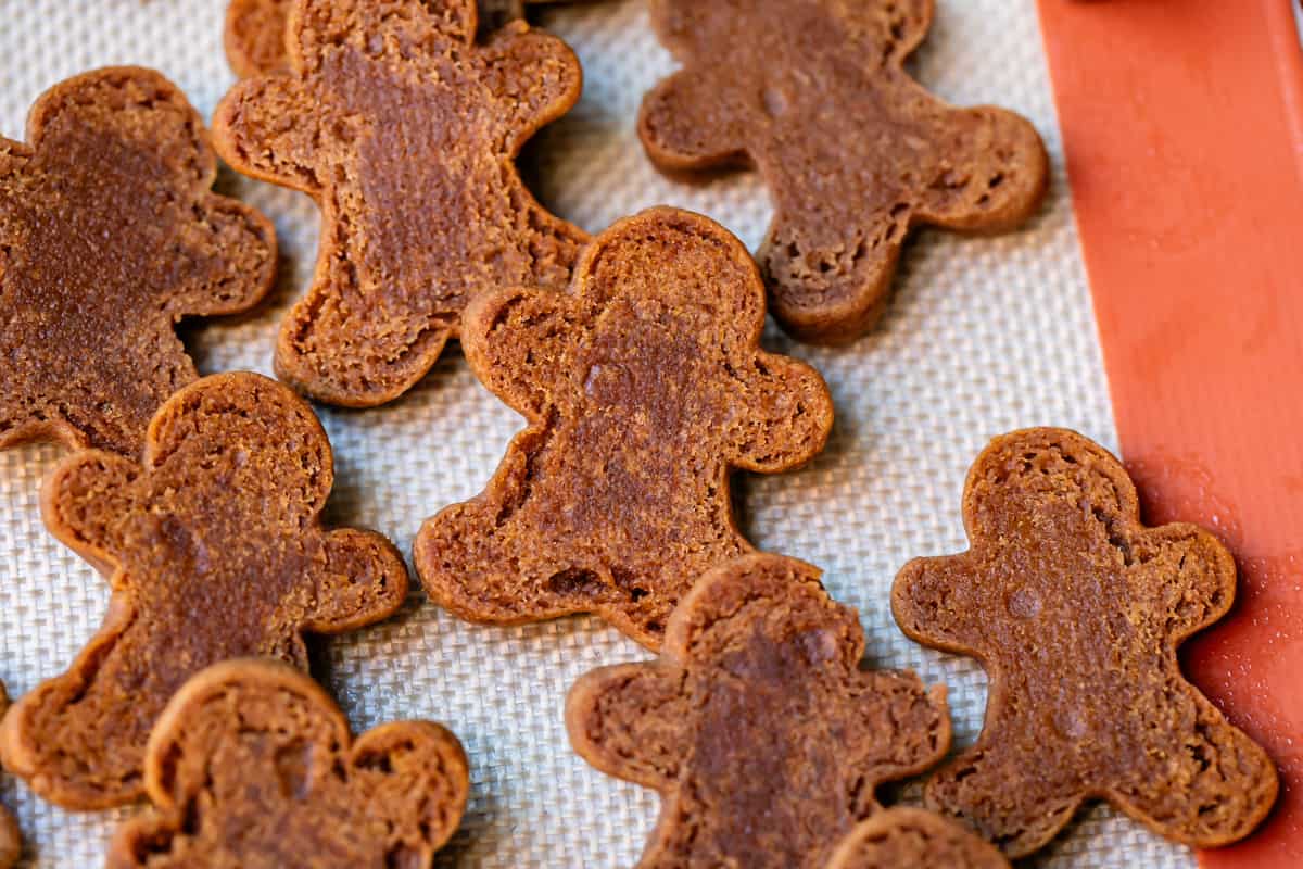 the flipped side of several gingerbread men showing dark spots that let you know they're still soft.