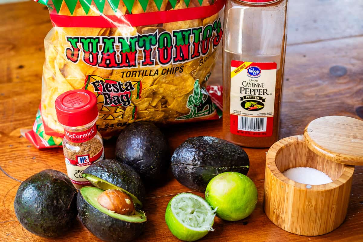 ingredients for gaucamole - avocado, lime, salt, cayenne, cumin, chips.