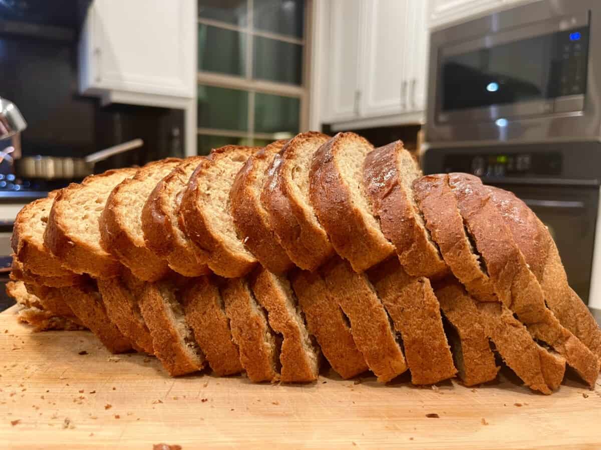 loaf of rye bread sliced on a cutting board.