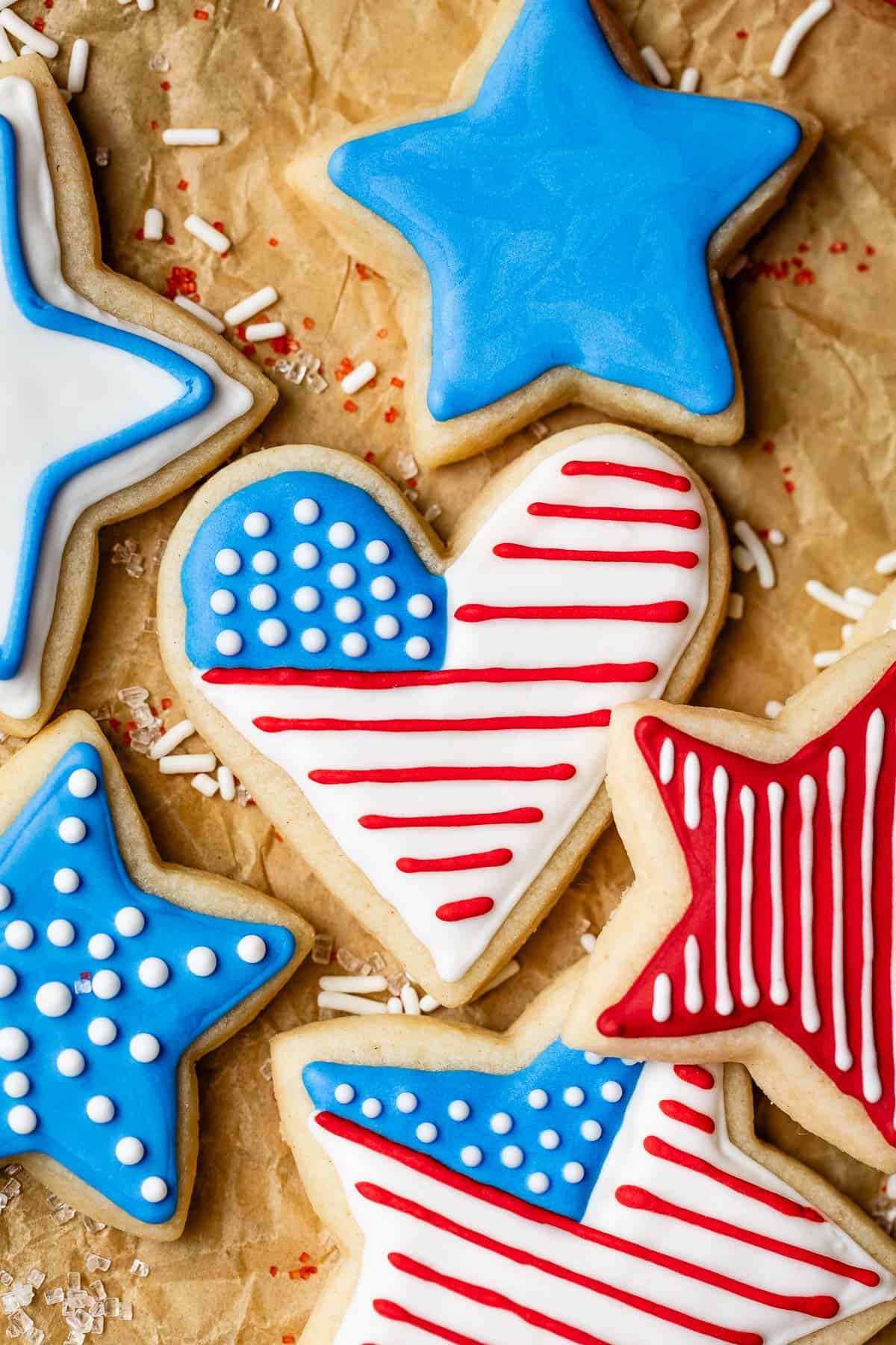Sugar cookies decorated for July 4th including heart and stars with red, white, and blue icing.