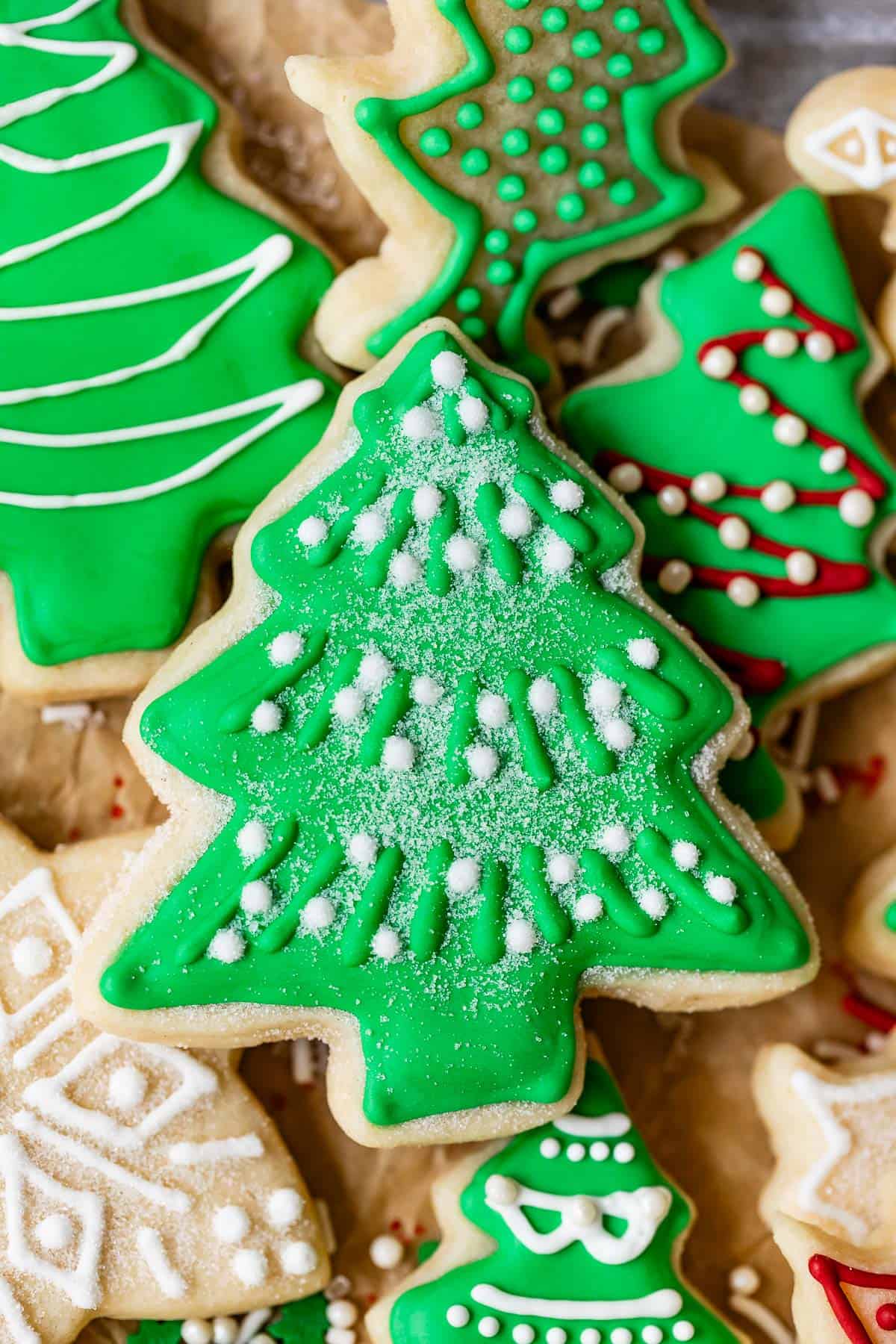 Christmas sugar cookies with royal icing designs including green frosting and sugar snow.