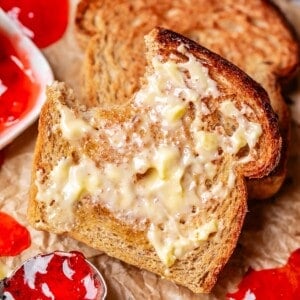 a bite taken out of a slice of buttered toast.