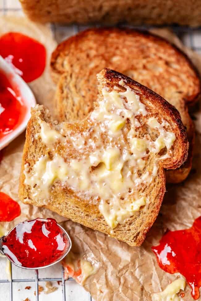 a bite taken out of a slice of buttered toast.