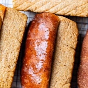 several loaves of bread lying on their sides to let cool with smooshing the bottom.