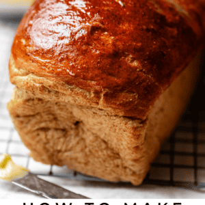 buttered loaf of rye bread on a cooling rack.