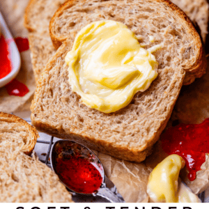 butter on a slice of rye bread with jam on the side.
