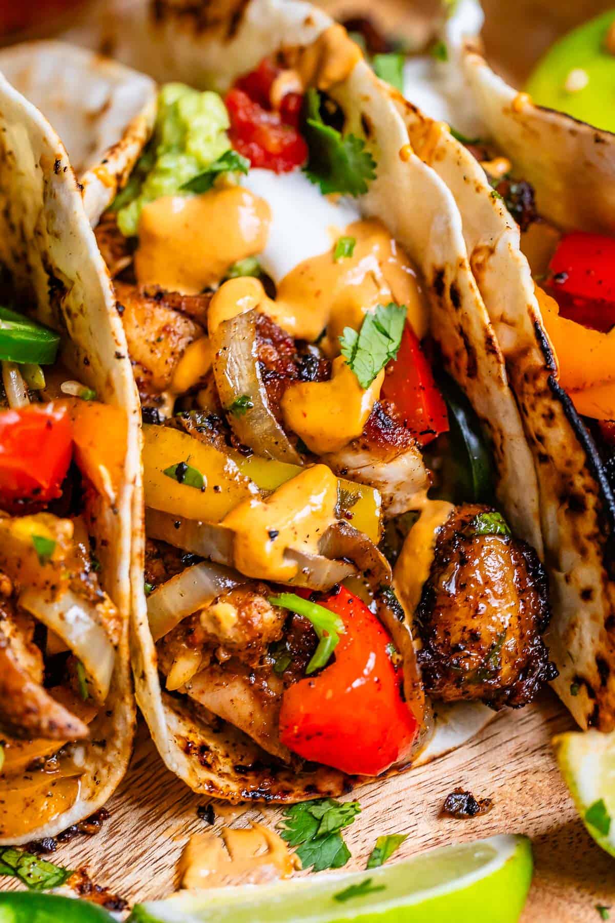 the juiciest chicken fajitas in a warm flour tortilla and topped with guacamole and sour cream.