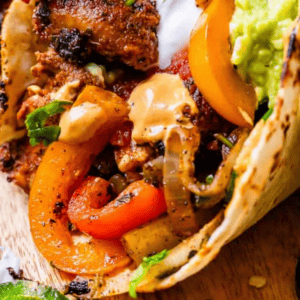 close up of a really full chicken fajita with text "seriously the best chicken fajitas you'll ever make".