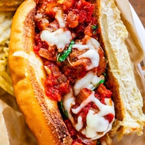 full toasted sub stuffed with meatballs in sauce and topped with cheese.