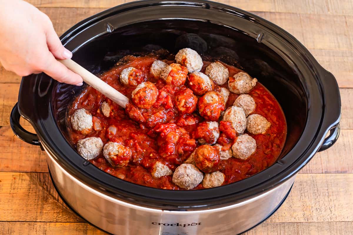 adding frozen meatballs to a crockpot that has the already transferred sauce in it.