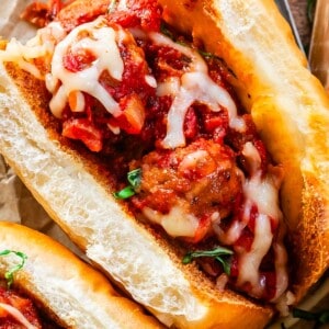 close up shot of a meatball sub with toasty buns, meatballs and sauce, and melty cheese.