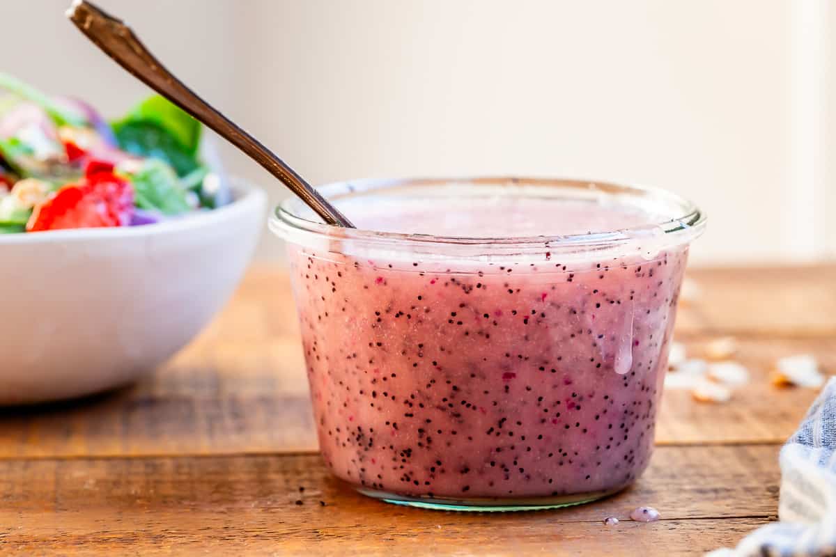 pink poppyseed dressing in a jar on a table.
